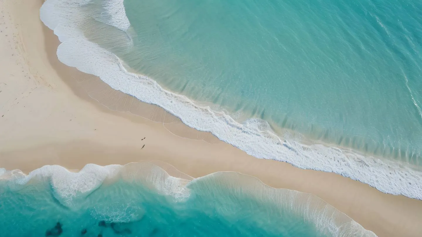 An aerial view of a pristine white sand beach meeting crystal clear turquoise waters creating natural geometric patterns captured from a top-down perspective bright October mist and sand colors high-quality ultra-realistic cinematic 8K UHD high resolution sharp and detail