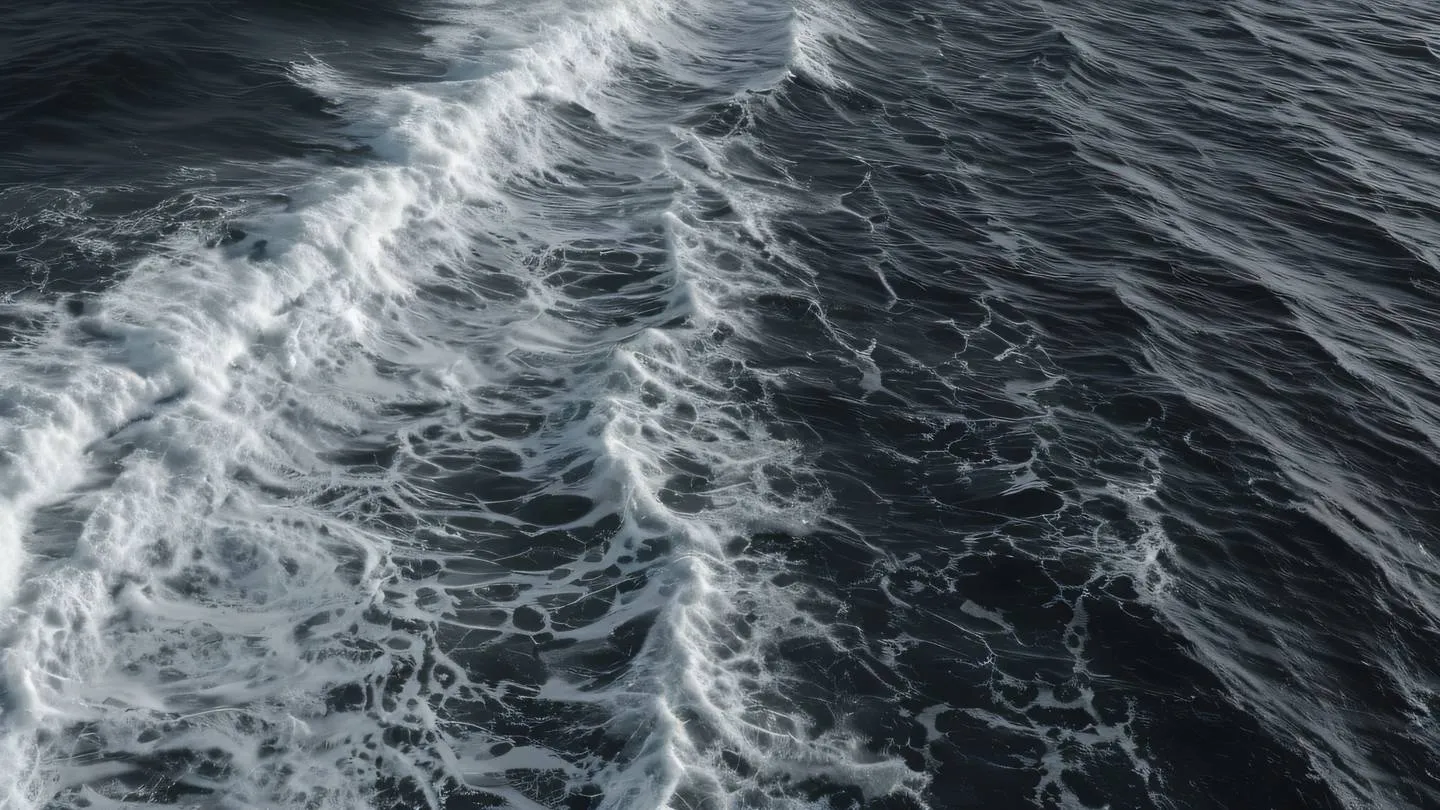 Ocean waves creating natural patterns viewed from aerial perspective in black and white tones with strong contrast between foam and water showcasing natural flow and movement high-quality ultra-realistic cinematic 8K UHD high resolution sharp and detail