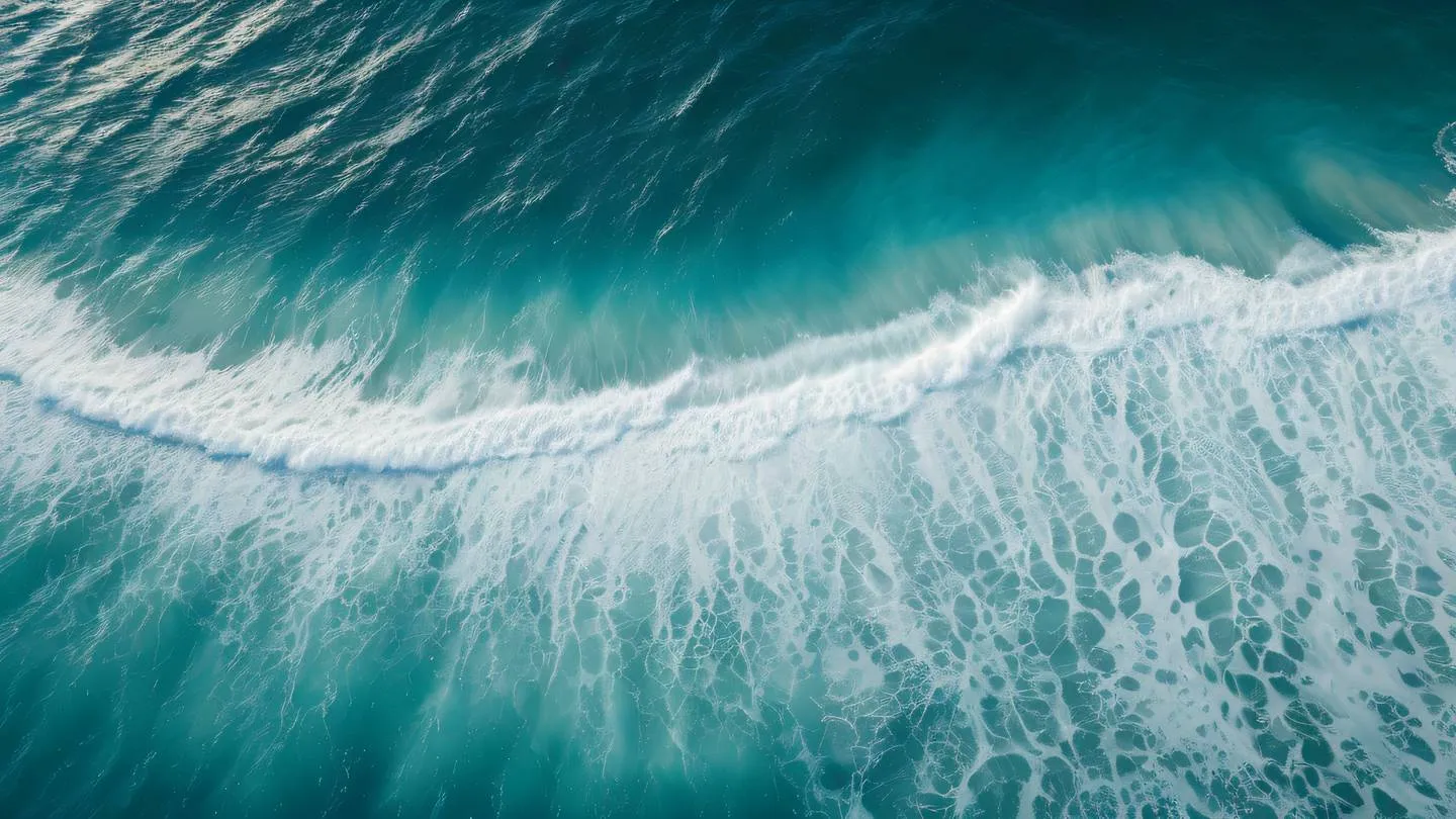 Aerial view of ocean waves creating natural patterns with foam featuring bright teal and creamy white colors captured from directly above high-quality ultra-realistic cinematic 8K UHD high resolution sharp and detail