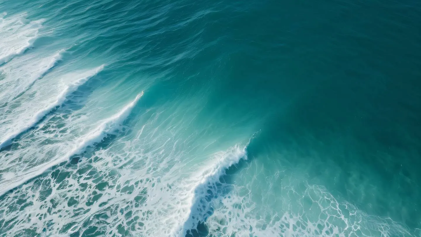 Ocean waves creating natural patterns viewed from above with bright white foam contrasting against deep turquoise water camera angle: bird's eye view high-quality ultra-realistic cinematic 8K UHD high resolution sharp and detail