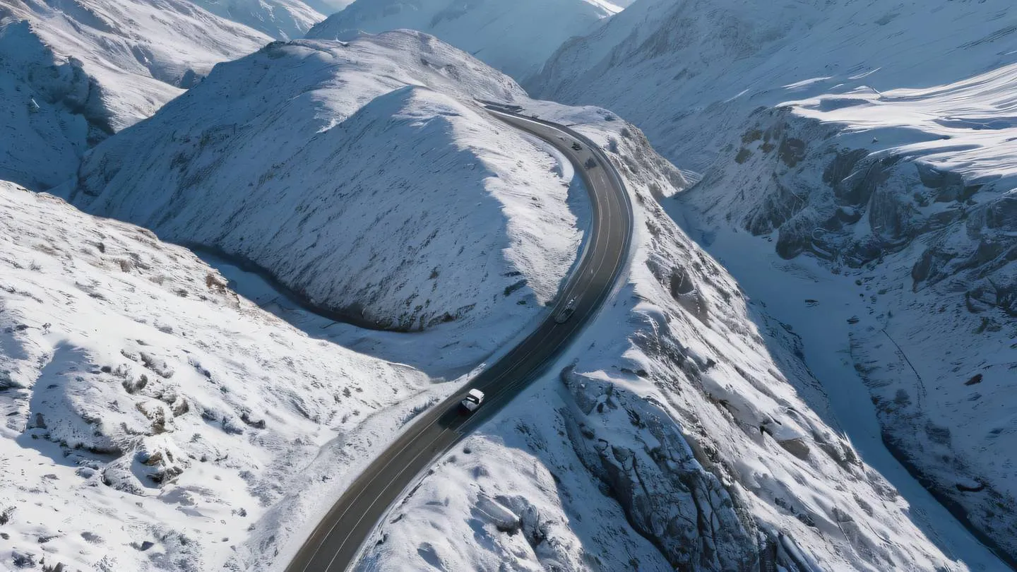 Aerial view of a winding mountain road through a snowy landscape illuminated by warm sunlight creating strong contrasts between bright white snow and gray rocky outcrops shot from a bird's eye perspective high-quality ultra-realistic cinematic 8K UHD high resolution sharp and detail