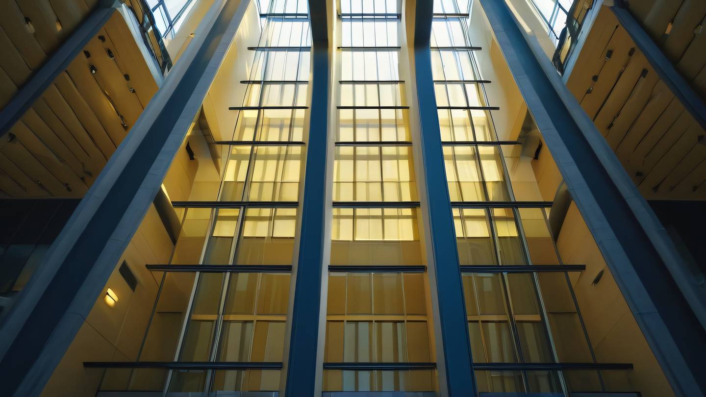Streams of light piercing through geometric architectural windows creating dramatic light rays in a modern atrium. The scene is bathed in warm yellow and navy blue gradients. Low angle shot looking upward. high-quality ultra-realistic cinematic 8K UHD high resolution sharp and detail