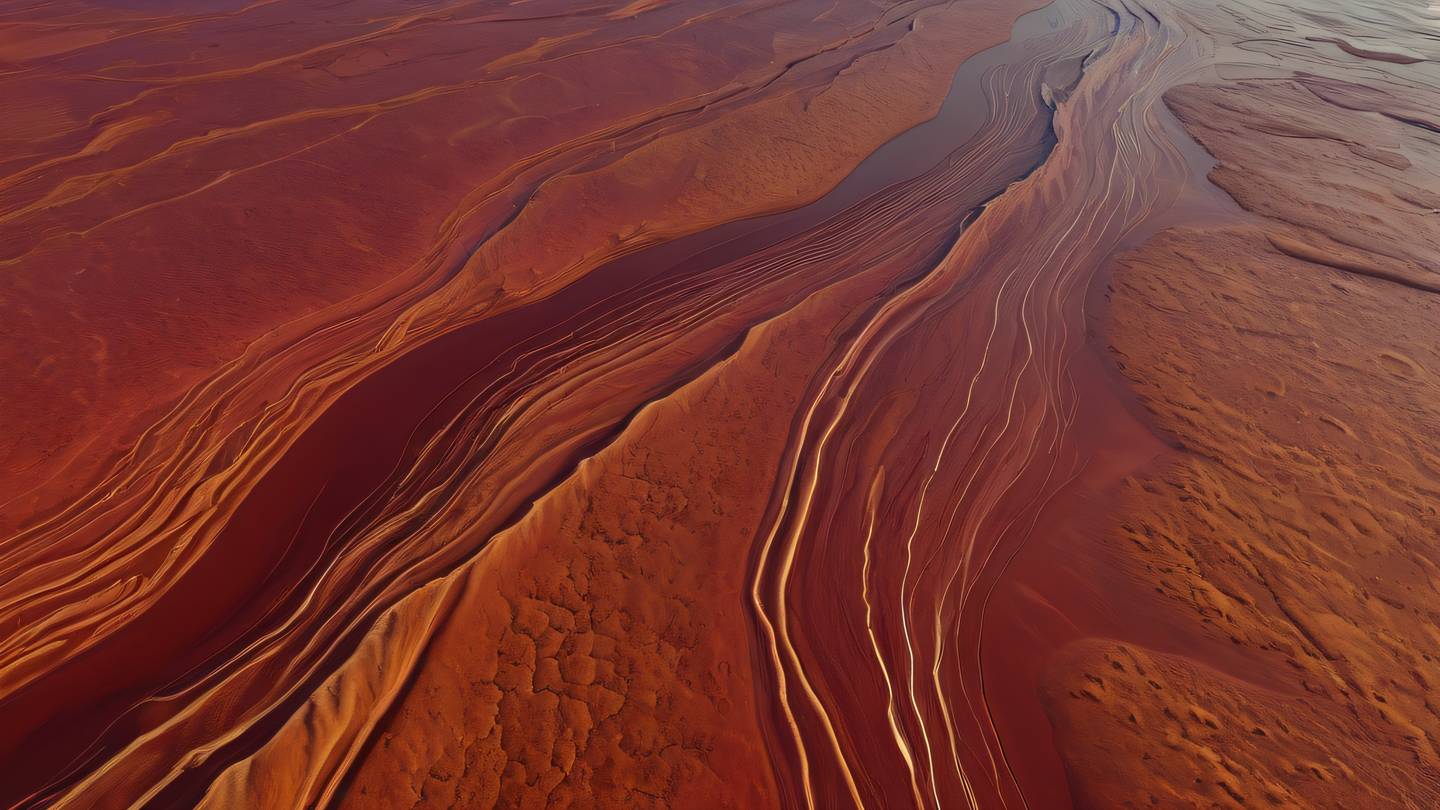 Abstract flowing water patterns in a river delta viewed from high above representing data streams and caching. Colors: Perfect red and ochre tones blend together in organic patterns. high-quality ultra-realistic cinematic 8K UHD high resolution sharp and detail